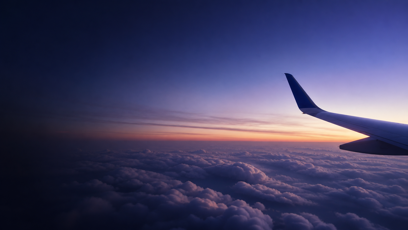 飛行機の窓から見える雲海と翼の背景
